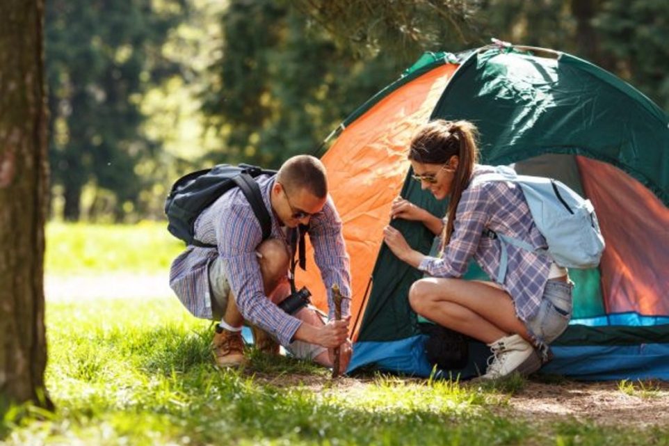 Couple setting up a camping tent