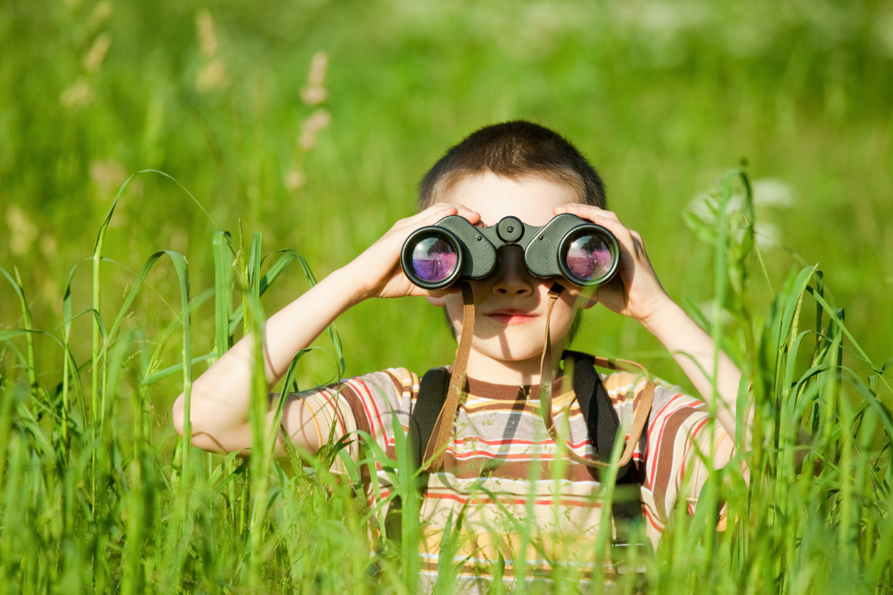 kid looking through binoculars